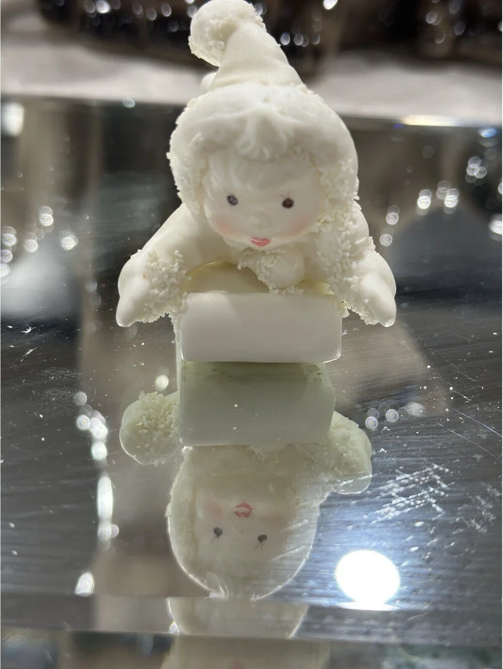 Department 56 Snowbabies figurine shows a baby dressed in a snowsuit playing